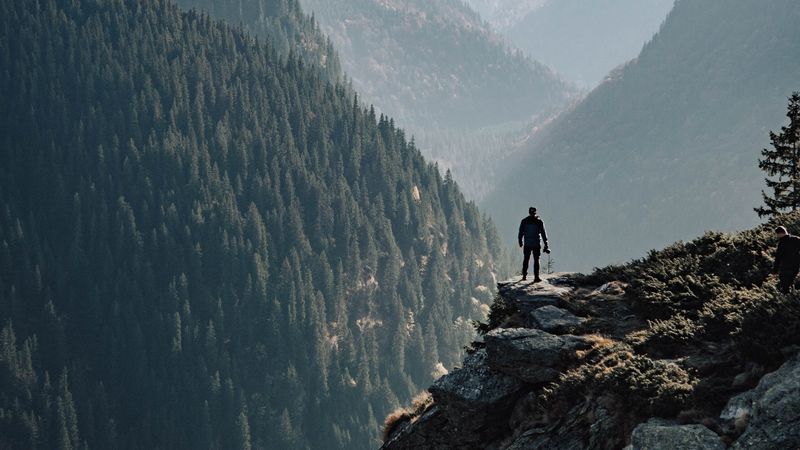 4K超清壁纸｜雾中山间岩石旁的男子