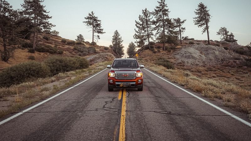 红色GMC峡谷德纳利版座驾 盘山公路与群山间的4K壁纸