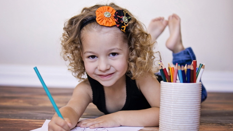 小女孩站在桌前画画的高清壁纸